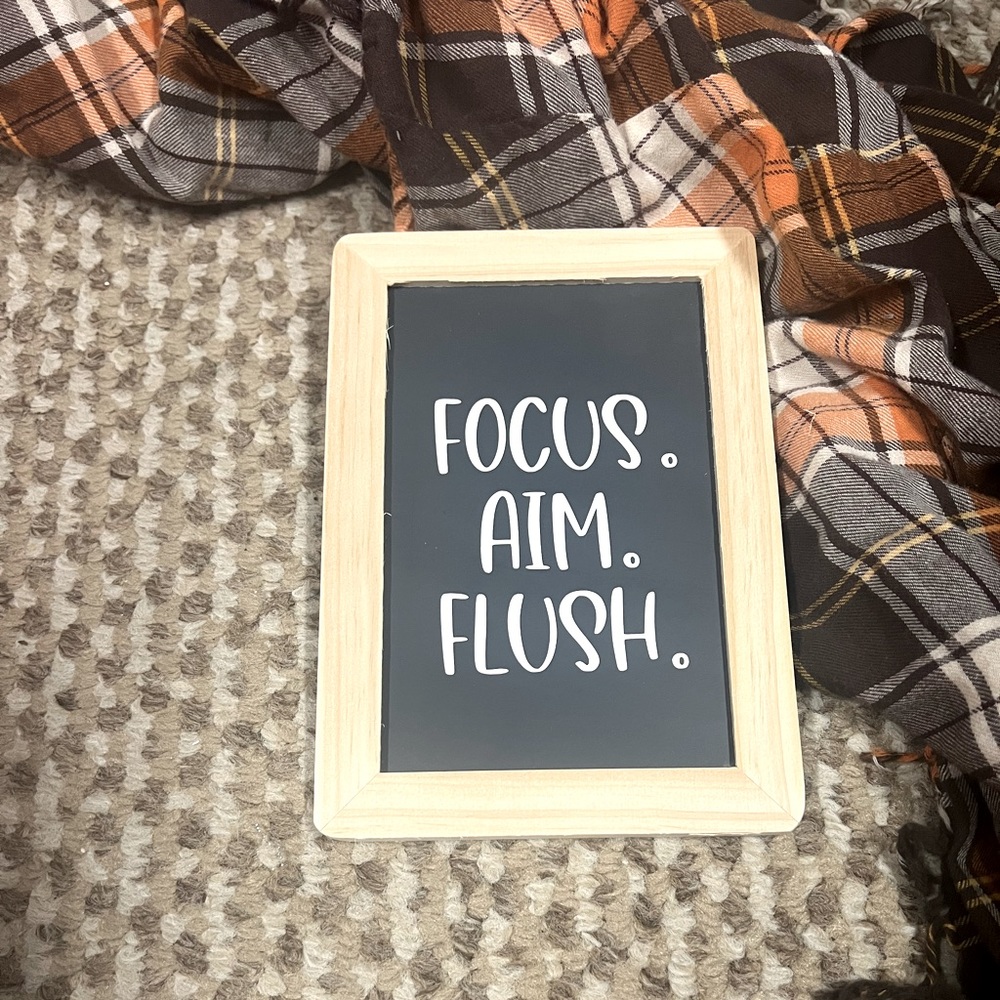 Chalkboard picture that says “Focus, Aim, Flush”